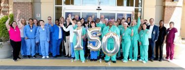 Team members hold silver 1-5-0 balloons celebrating inclusion on Becker's list of top 150 places to work in health care.