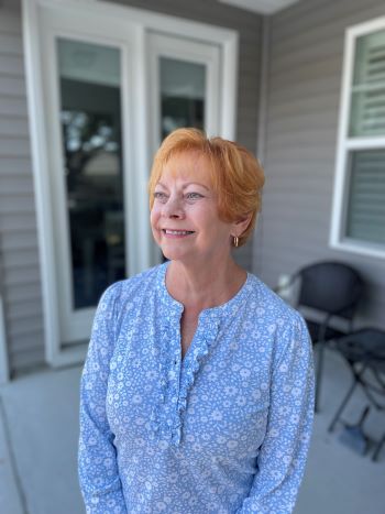 Breast cancer survivor Sally Humphrey standing outside looking to the side.