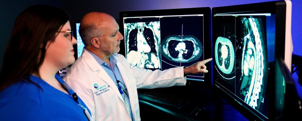 two radiologists review a monitor image.