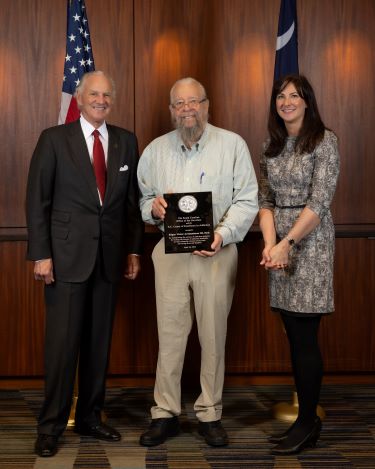 Dr. Victor Archambeau holds the award he received standing next to Gov. Henry McMaster.