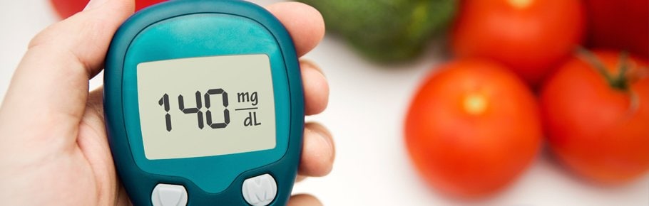 A hand holds the device used to check their blood sugar levels.