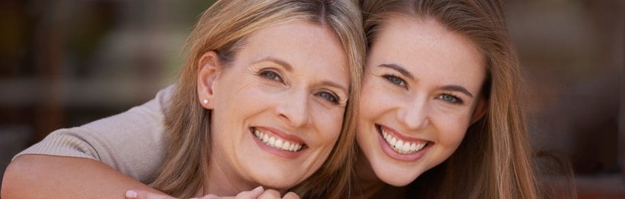 A mother and daughter smiling.