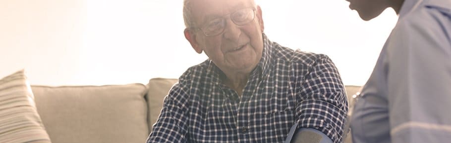 A senior gentleman talks to his home health nurse.