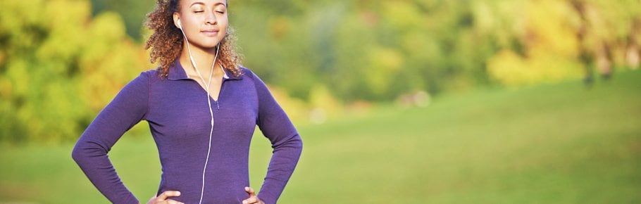 A woman prepares for a run while wearing headphones.