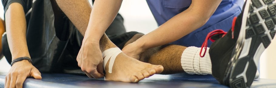 A health care provider assists a patient with a wound.