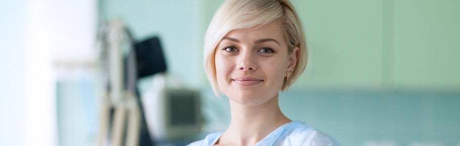 A lady in a hospital room smiling