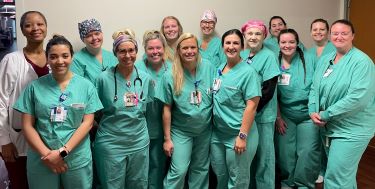 Nurses and other care team members in scrubs posing for a photo.