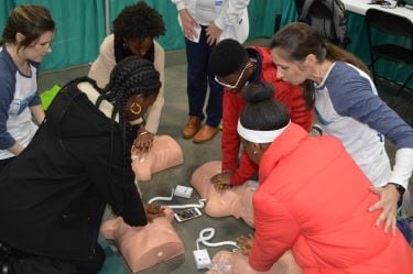 Students practice CPR techniques with guidance from Tidelands Health professionals.