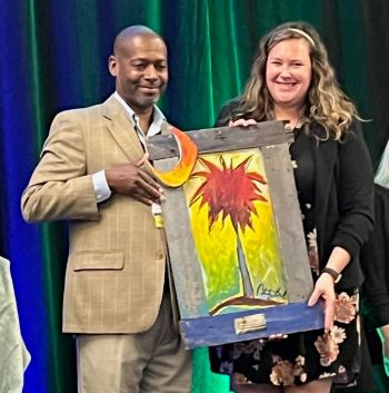 South Carolina Office of Rural Health presents the Outstanding Community Health Project award - an artist's creation of the Palmetto tree and moon - to Kelly Kaminski, senior director of community health for Tidelands Health.